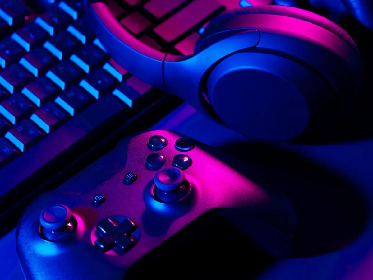 Kontroler, slušalice i tastatura pod neonskim svetlom